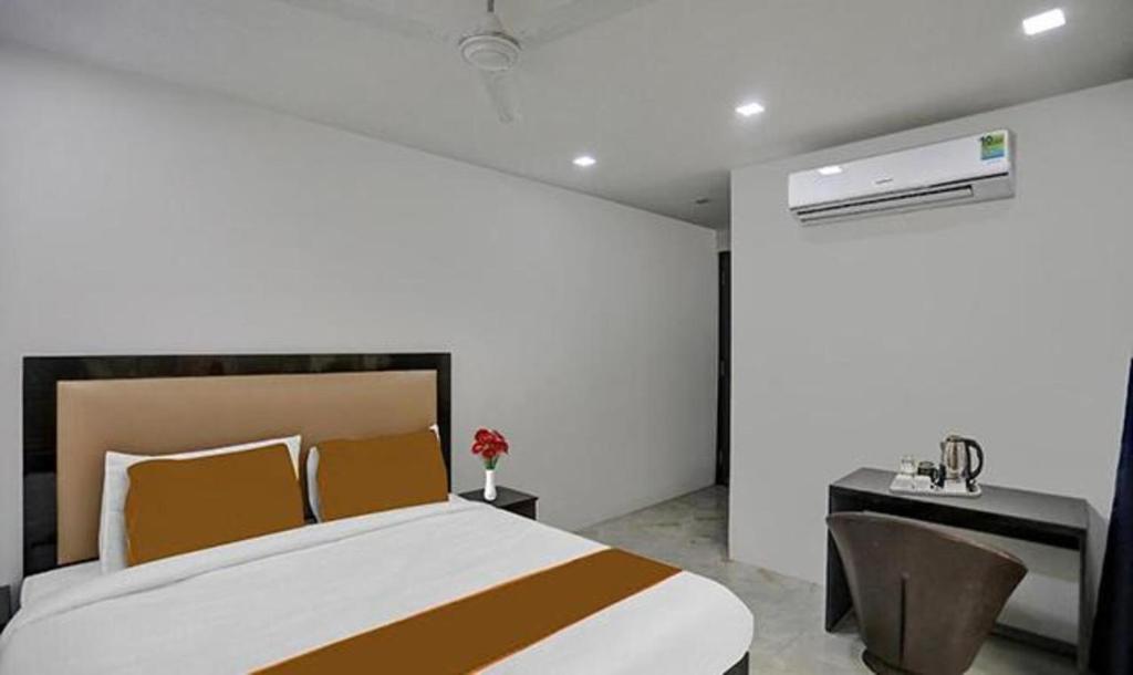 Dormitorio con cama grande, escritorio y cama sidx sidx en FabExpress Mannat, en Nueva Delhi