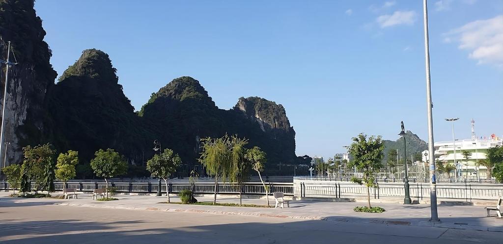 a park with benches in front of some mountains at Hải Quân Motel in Ha Long