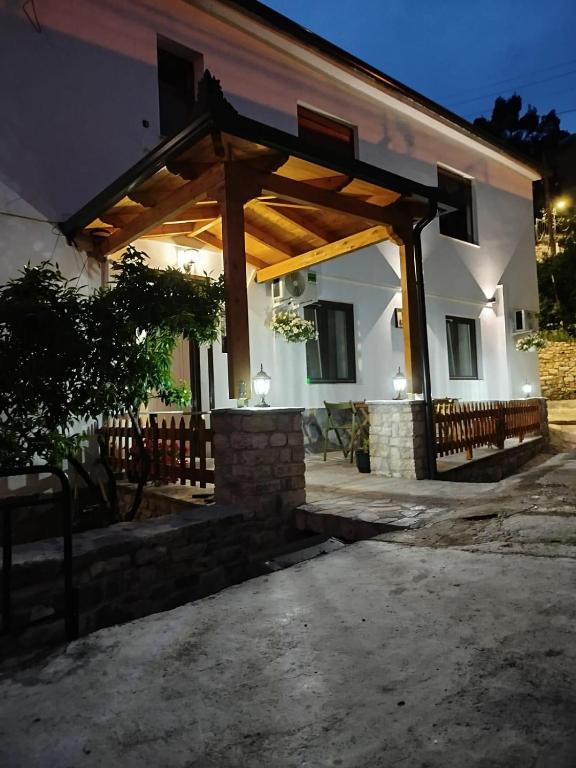 una casa con un padiglione in legno di fronte ad essa di Hotel Vila Vreko B&B a Berat