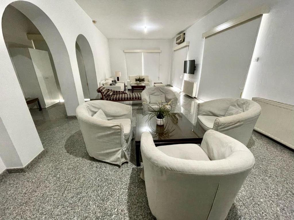 a living room with white chairs and a table at Spacious Apartment by Platform 357 in Nicosia