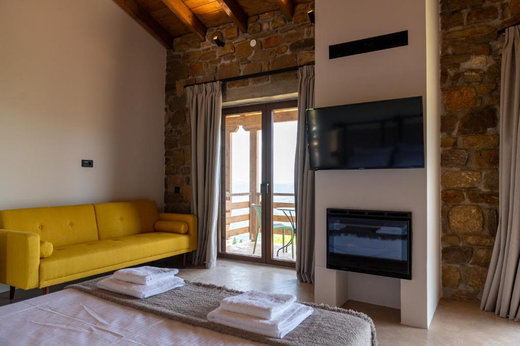 ein Wohnzimmer mit einem gelben Sofa und einem Kamin in der Unterkunft Άνδηρο in Synikia Mesi Trikalon