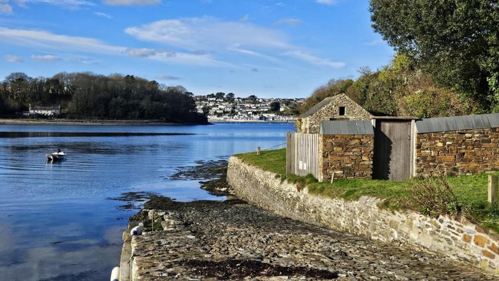 a stone building on the side of a river at Lavender Cottage in Porthscatho