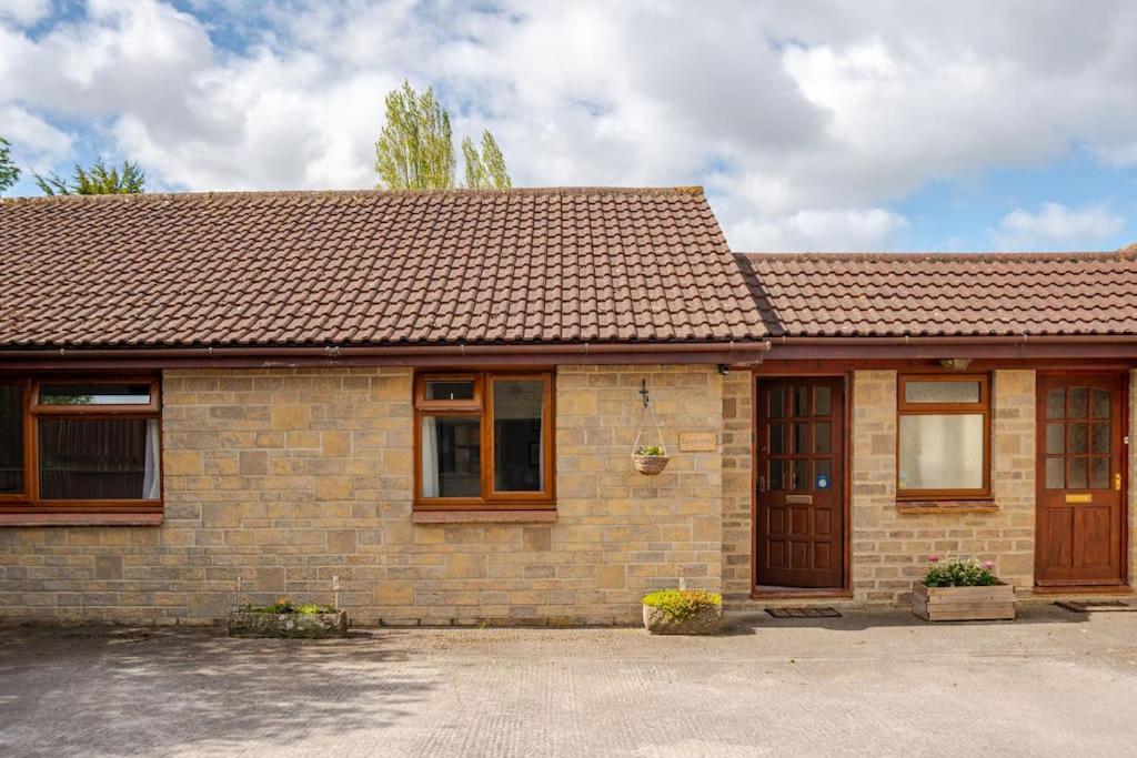 a brick house with a brown roof at Tanglewood in West Ashton