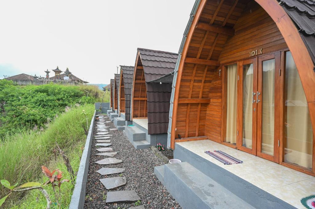 a row of wooden houses on the side of a hill at Volcano Cabin Batur RedPartner in Baturaja