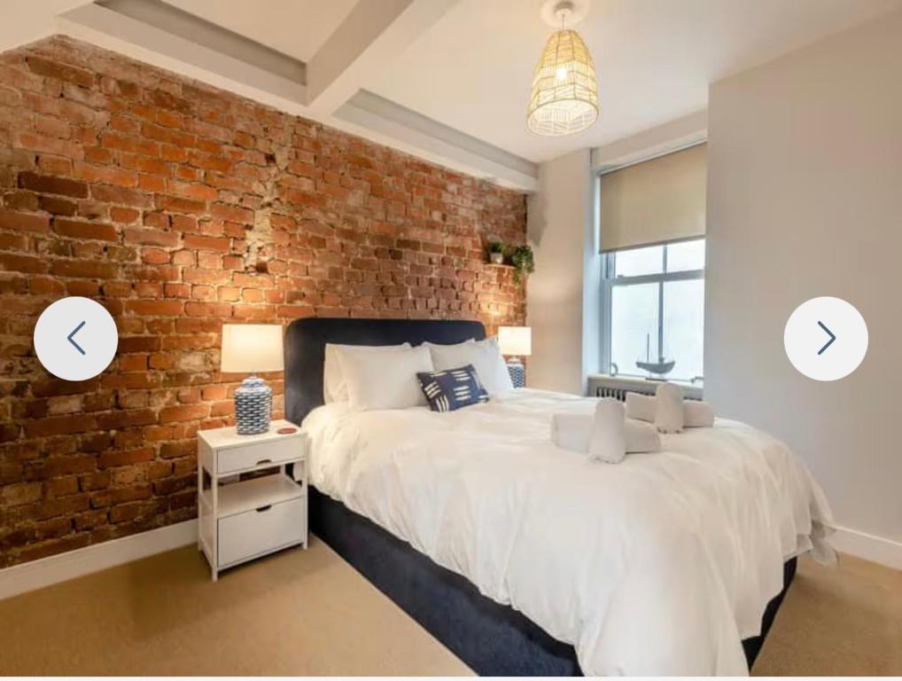 a bedroom with a brick wall and a bed at Ferrymans Rest in Dartmouth