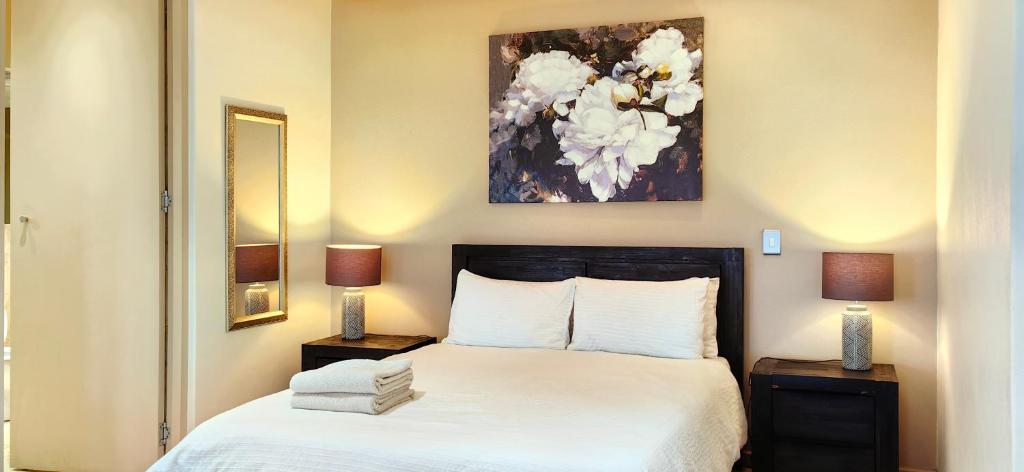 um quarto com uma cama e duas mesas de cabeceira com dois candeeiros em 4 on Pritchard Luxury Suites em Joanesburgo