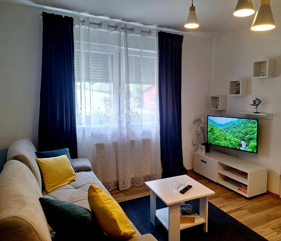 a living room with a couch and a television at Gospic Riverside Apartment in Gospić