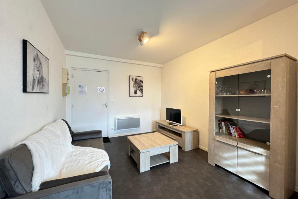 a living room with a couch and a table at Côté jardin appartement centre Gramat in Gramat