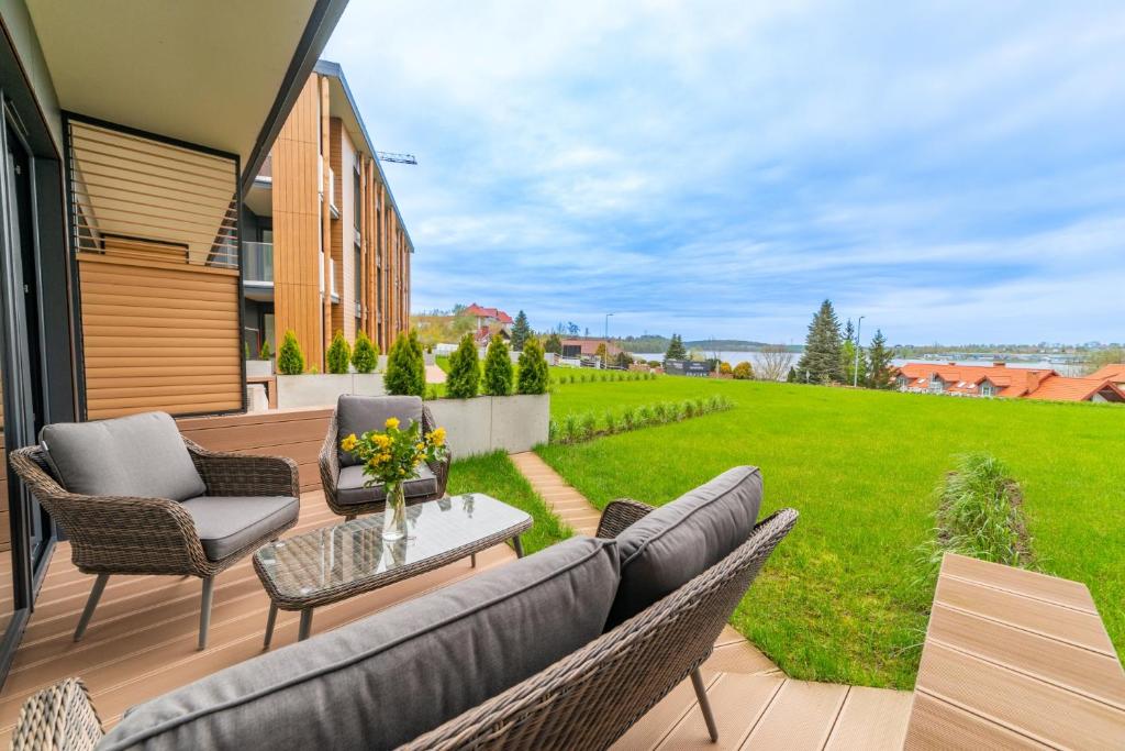 a patio with a couch and chairs and a table at Lake Rental Pratum 24 in Mikołajki