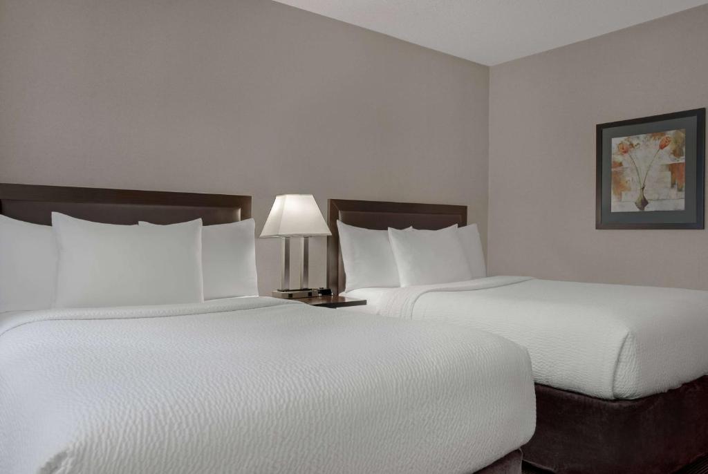 Postel nebo postele na pokoji v ubytování Ramada Plaza by Wyndham Calgary Downtown