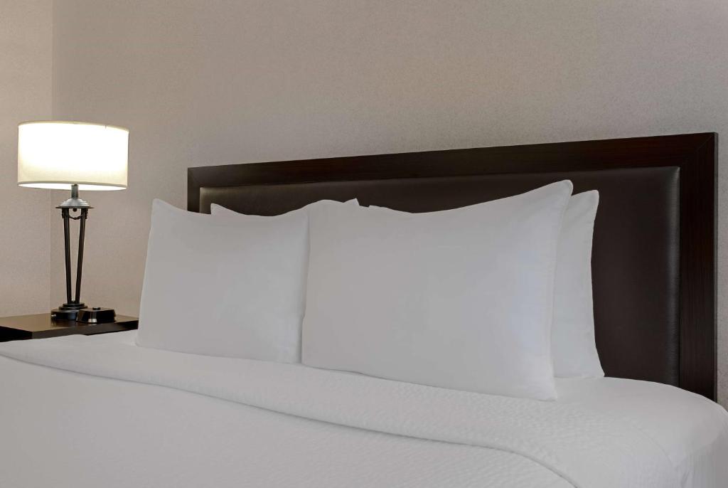 Postel nebo postele na pokoji v ubytování Ramada Plaza by Wyndham Calgary Downtown