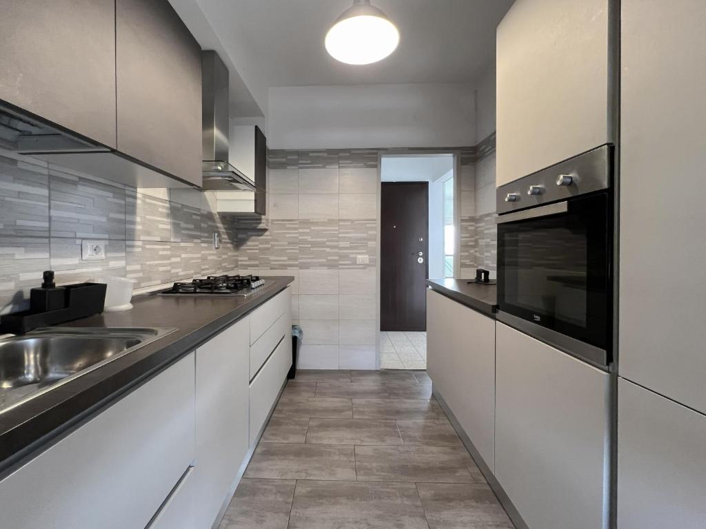 una cocina con armarios blancos y fregadero en Atlantico Apartment, en Roma