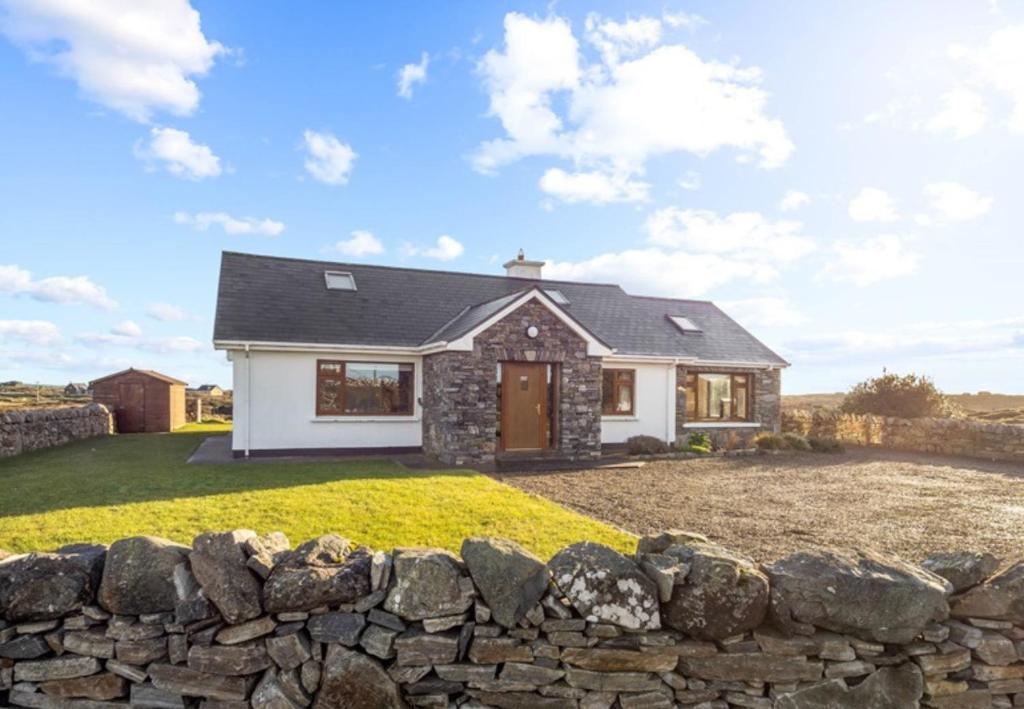 a house with a stone wall at Rugosa, Ballyconneely in Ballyconneely