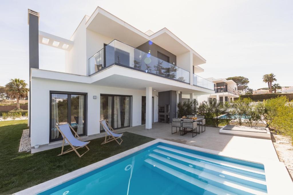 uma villa com uma piscina e uma casa em Pérola Lux Villa no Vau