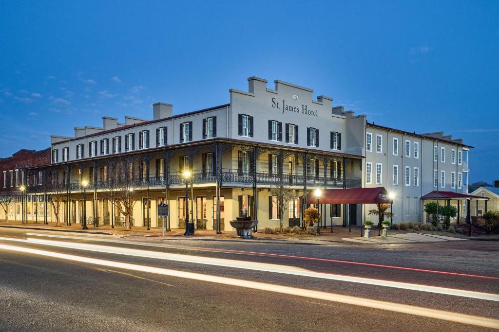a large white building on a city street at night at St James Hotel Selma Tapestry Collection by Hilton in Selma