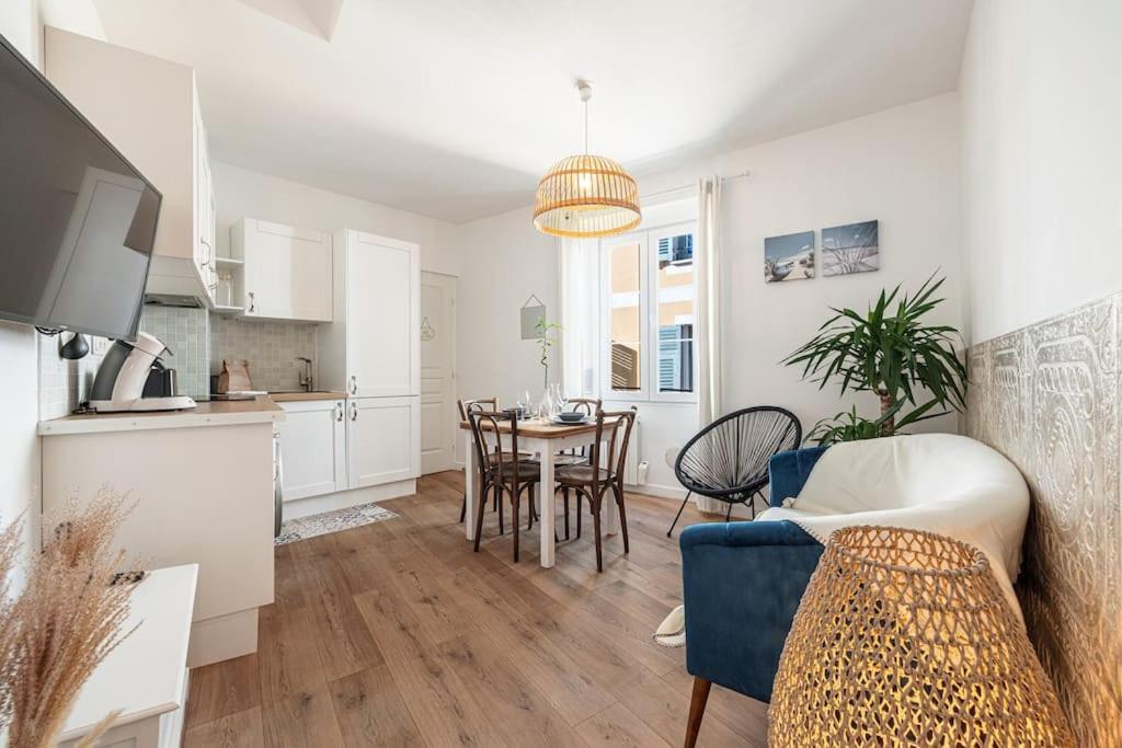 une cuisine et un salon avec une table et des chaises dans l'établissement Magnifique appartement au cœur du Vieux Nice, à Nice
