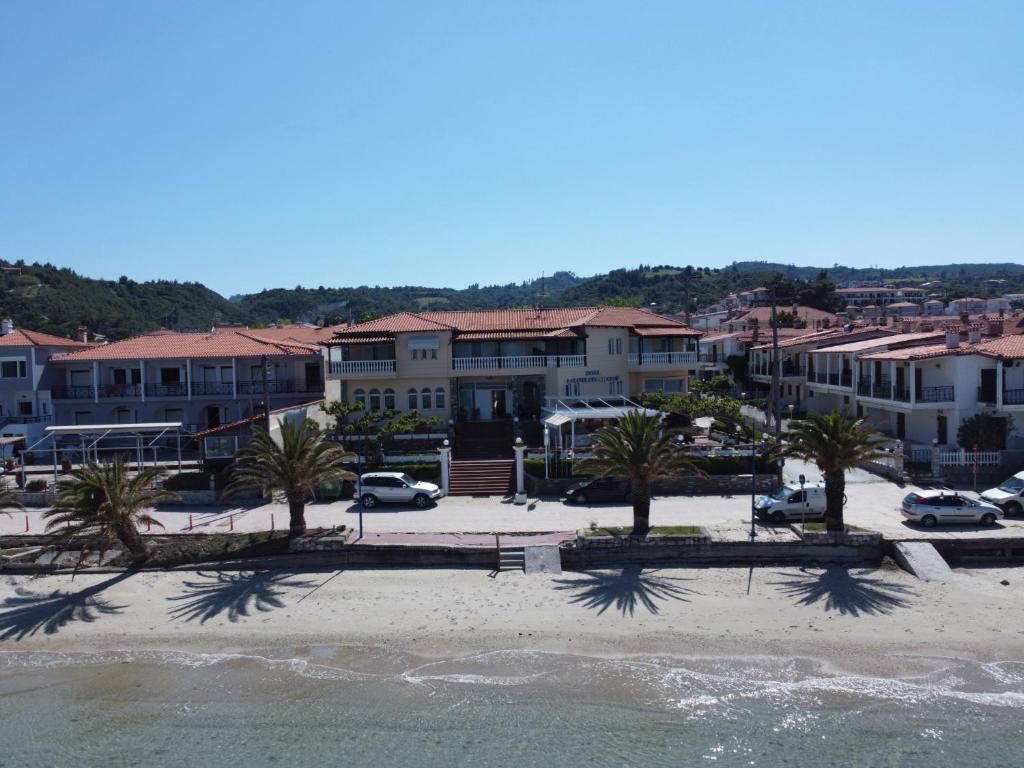 - une vue sur une plage bordée de palmiers et de bâtiments dans l'établissement Polychrono Beach Hotel, à Polychrono