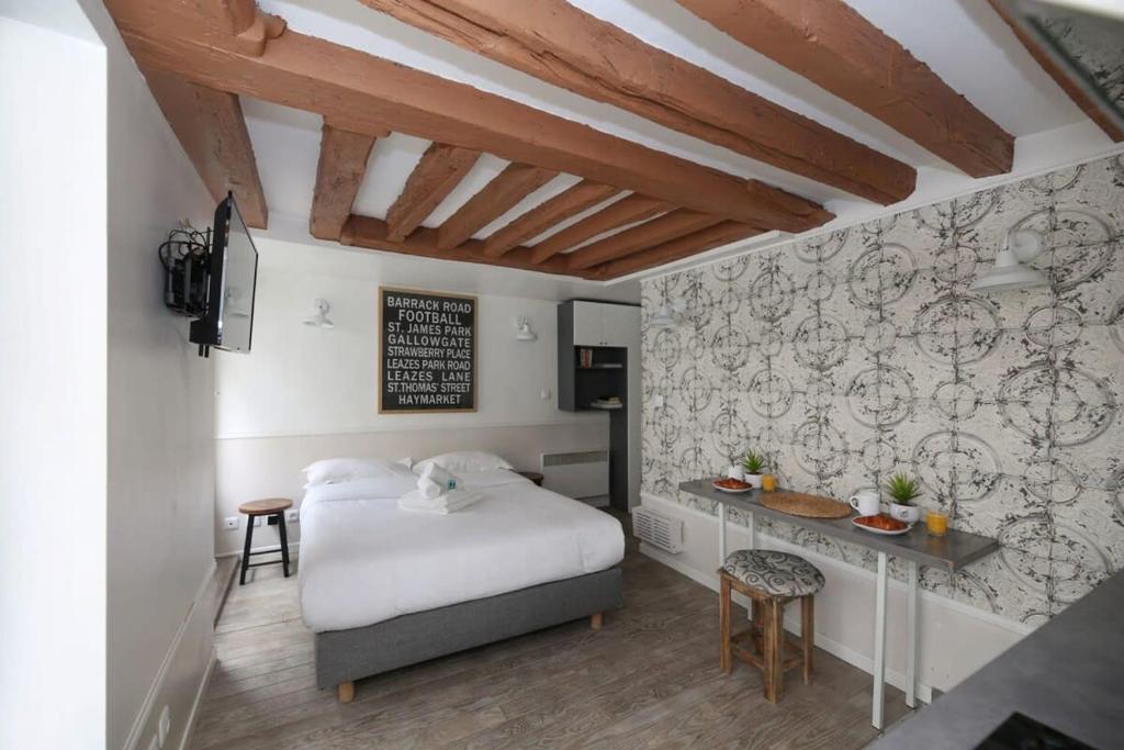 a bedroom with a bed and a desk in it at Studio parisien 20m2 en face du musée Grévin - 2P in Paris