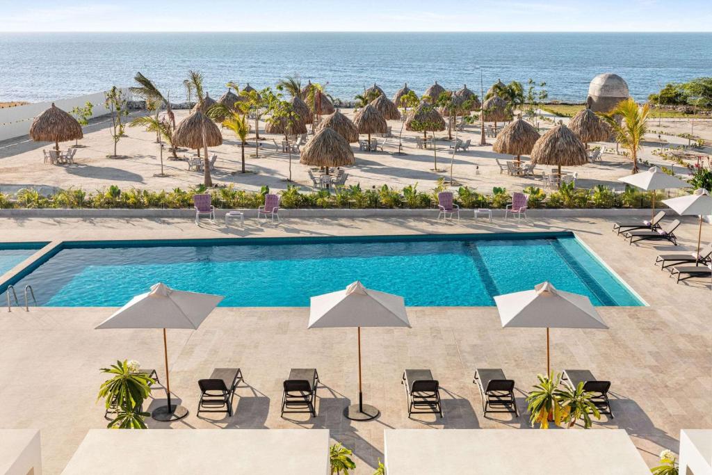 uma vista superior de uma piscina e do oceano em Wyndham Santa Marta Aluna Beach em Santa Marta