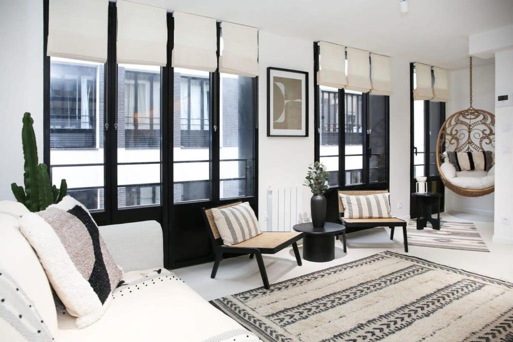 - un salon avec un canapé blanc et quelques fenêtres dans l'établissement Appartement de caractère aux portes du Marais - 4P - FLAT-GUEST, à Paris