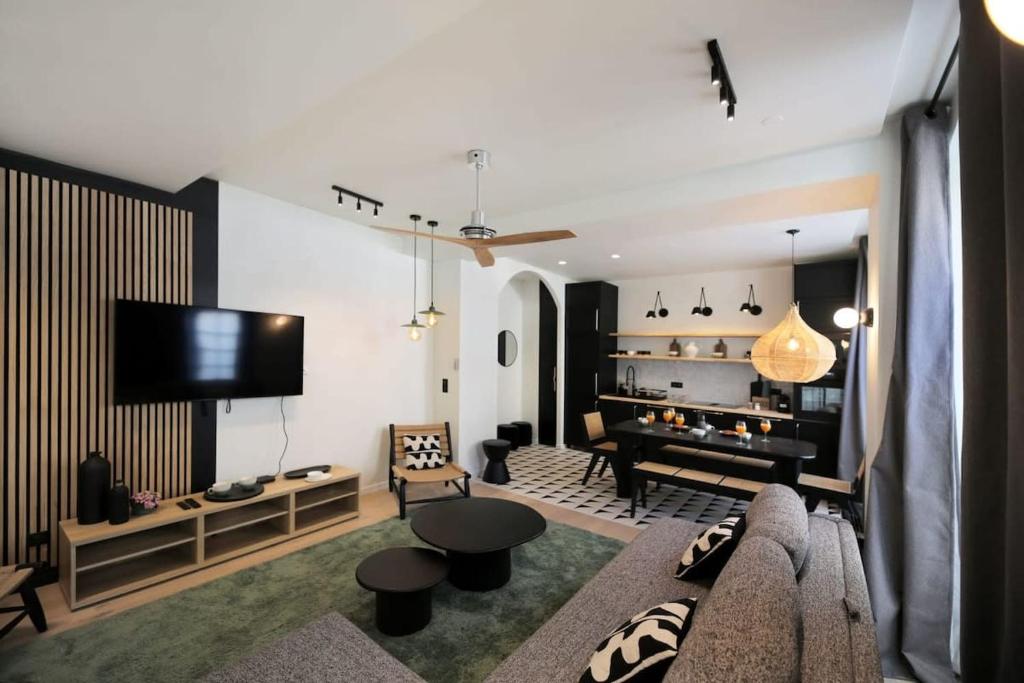 un salon avec un canapé et une télévision à écran plat dans l'établissement Appartement familiale sauna Paris 10 - 8P - FLAT-GUEST, à Paris