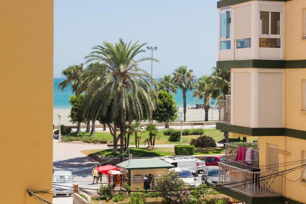 une vue sur la plage depuis le balcon d'un immeuble dans l'établissement Fabuloso apartamento a 50m de playa centrico, à Torre del Mar