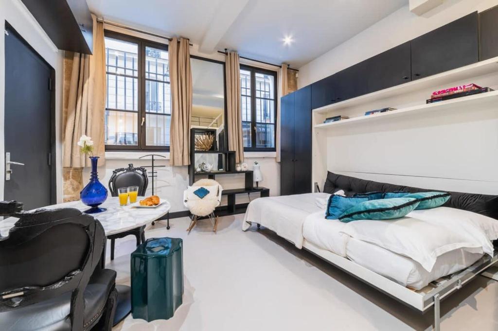 une chambre avec un grand lit et un bureau dans l'établissement Studio refait a neuf a montorgueil - Paris 2 - FLAT-GUEST, à Paris