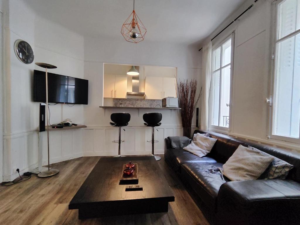 een woonkamer met een bank en een salontafel bij Nice and cozy 1b apartment in the heart of Paris in Parijs