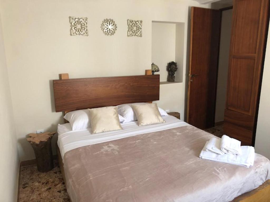 1 dormitorio con 1 cama grande y 2 toallas. en Quiet Getaway House in Alcala De Los Gazules, en Alcalá de los Gazules