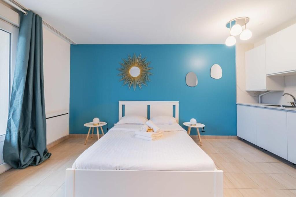 a blue bedroom with a bed and a blue wall at Studio Lumineux et Élégant à La Courneuve -2P in La Courneuve