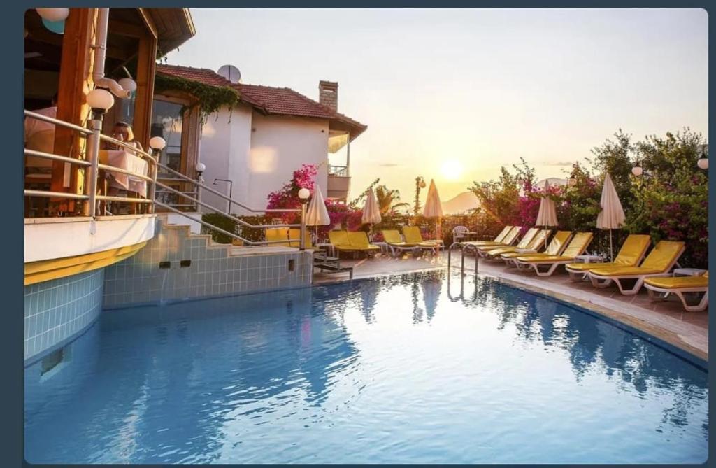 una piscina con sedie e ombrelloni in un hotel di SunStar Kleopatra beach a Alanya