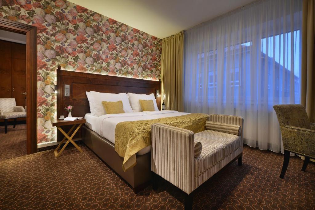 une chambre d'hôtel avec un lit et une chaise dans l'établissement Vysocina Design Apartments, à Hlinsko