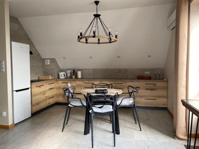 a kitchen with a table and chairs and a chandelier at Apartament Portowy in Mikołajki