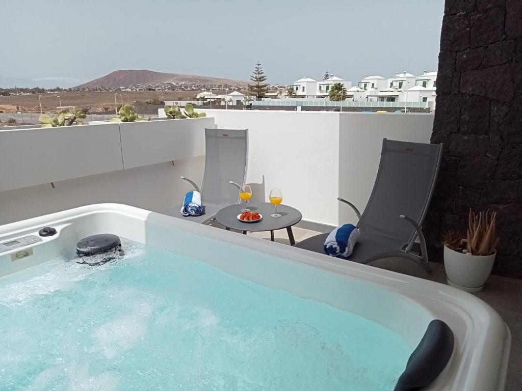 a hot tub on a balcony with a table and chairs at Nunoli Duplex Luxury Playa Blanca in Playa Blanca