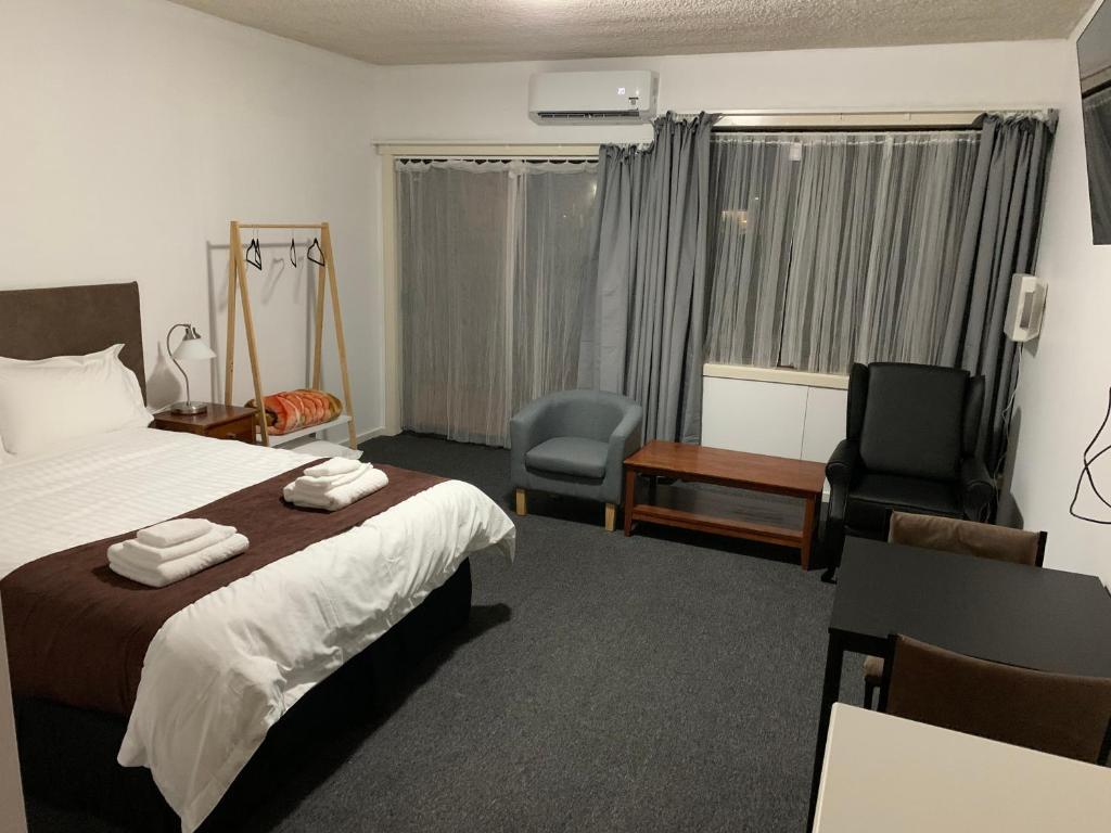 瑟爾的住宿－The Reserve Hotel，酒店客房,配有一张床、一张桌子和椅子