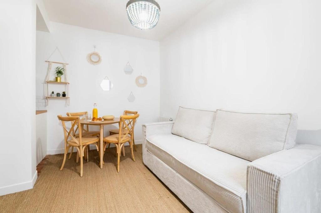 un salon avec un canapé blanc et une table dans l'établissement Jolie 2 pieces 35m2 bien équipée 4P - Paris 20 - FLAT-GUEST, à Paris