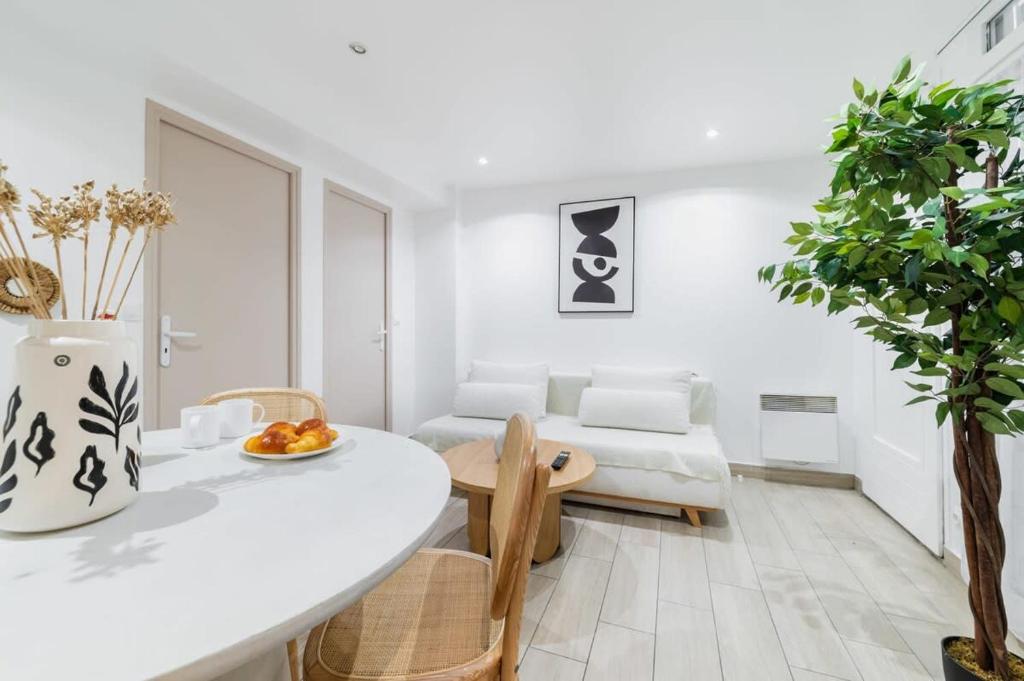 un soggiorno bianco con tavolo e divano di Espace moderne 40m2 a deux pas de Paris - 4P a Les Lilas