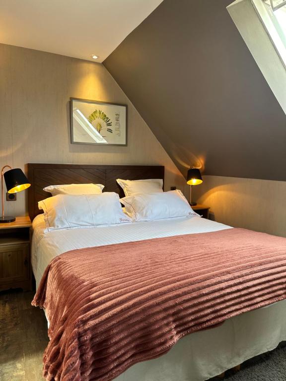 una camera da letto con un grande letto in mansarda di Camélia a Bayeux