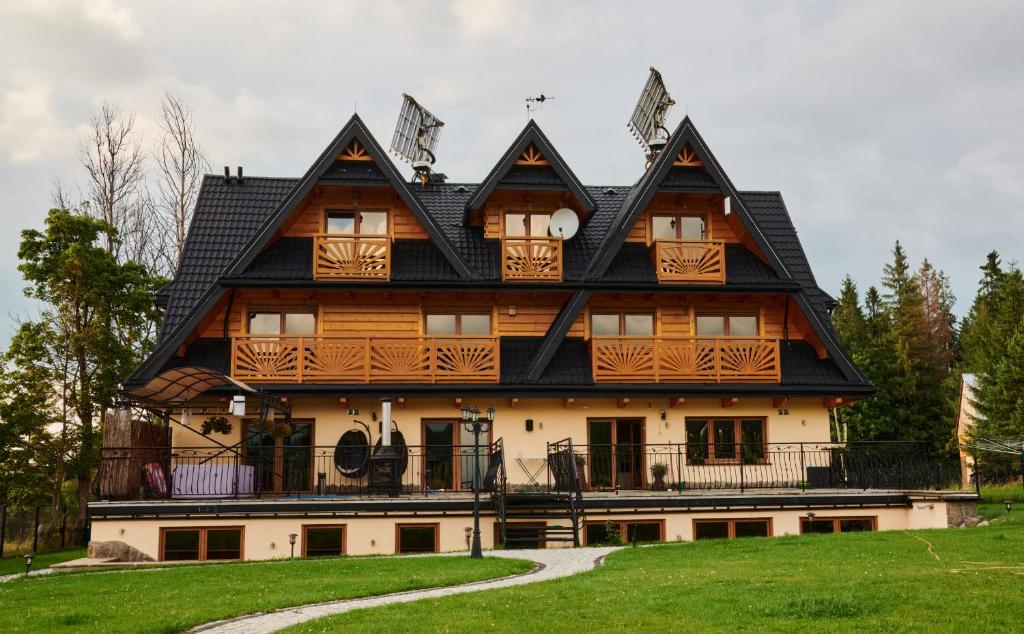 a large wooden house with a gambrel roof at Highland Retreat Dzianisz in Witów