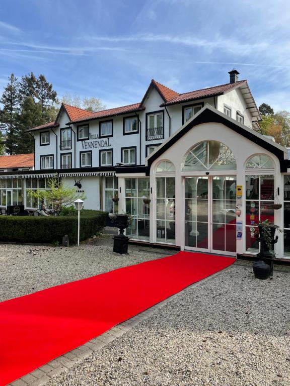 alfombra roja frente a un gran edificio en Landgoedhotel Villa Vennendal, en Nunspeet