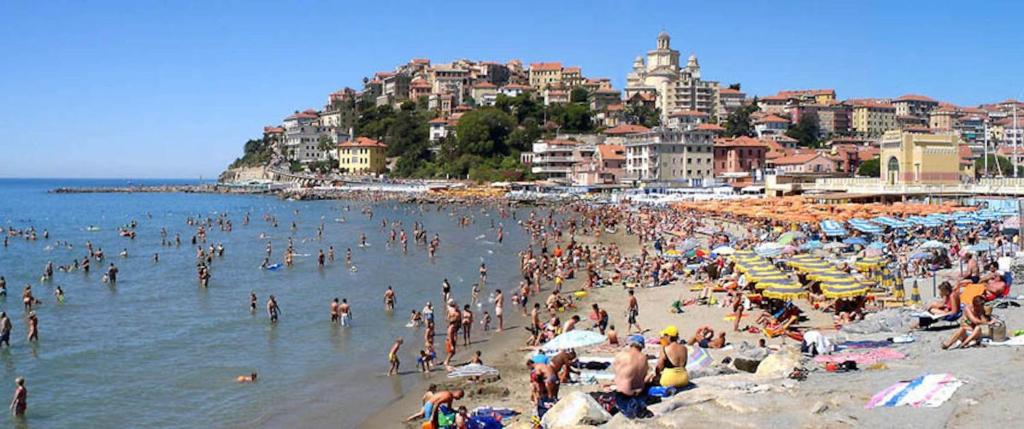 a crowd of people on a beach with buildings at Casa Marina 50 mt dal mare in Imperia