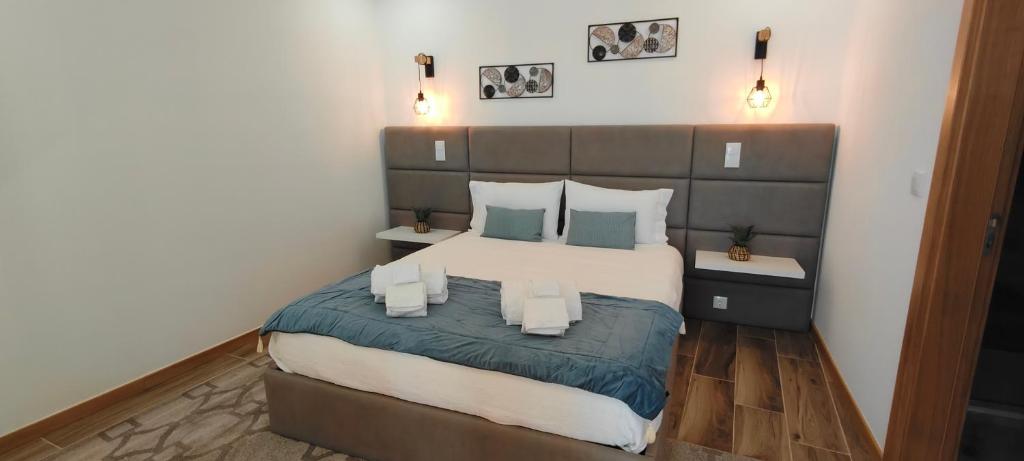 a bedroom with a large bed with blue and white pillows at Suíte Leonor in Alijó