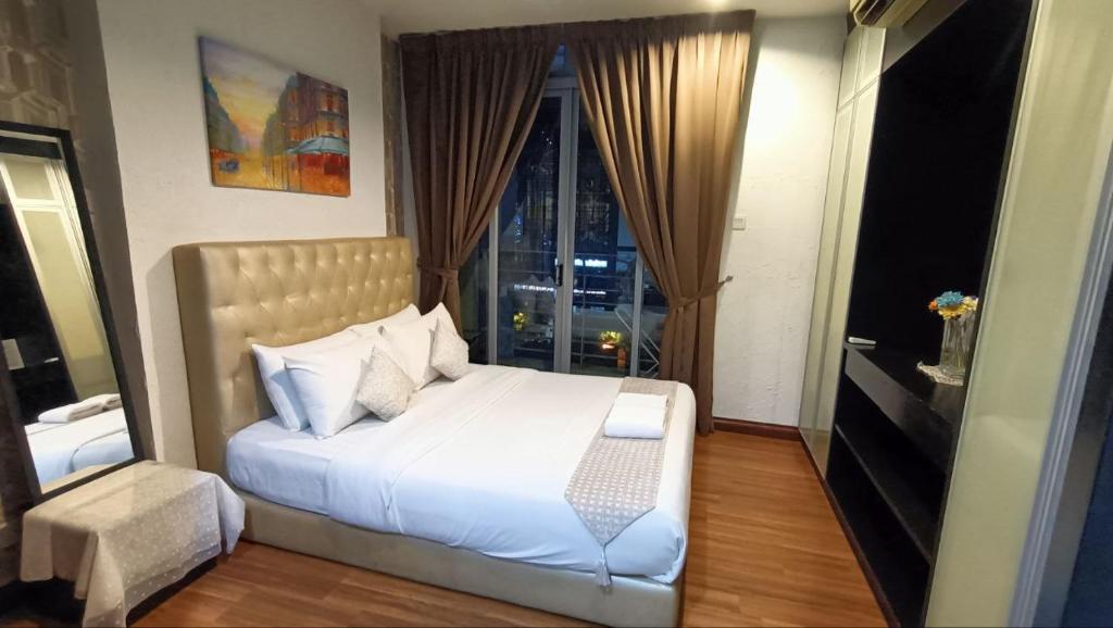 1 dormitorio con cama blanca y ventana en Taragon Time Service Suite en Kuala Lumpur