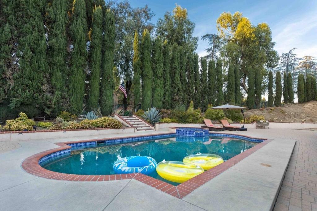 een zwembad met opblaasbare bedden in een tuin bij Colven by AvantStay Pool Spa Near Golf Course in Los Angeles