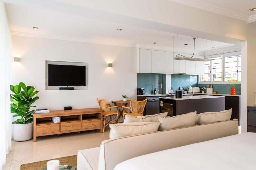 een woonkamer met een bank en een keuken bij Riverside Studio apartment with parking in Brisbane