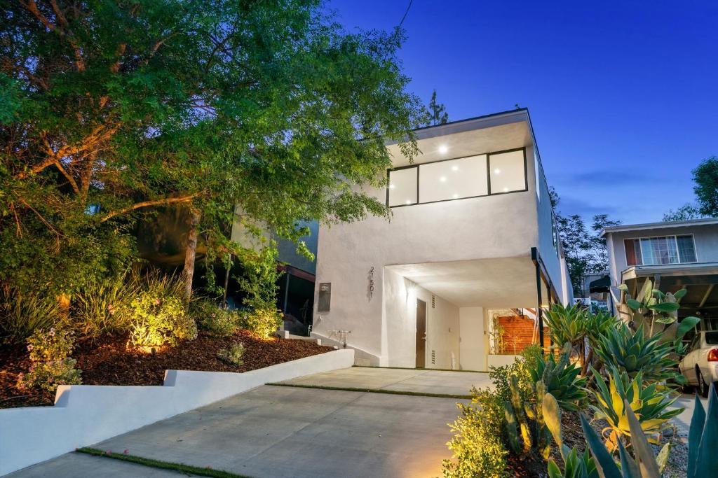 une maison blanche avec un garage et des arbres dans l'établissement Dumetz by AvantStay Large Private Outdoor Area, à Los Angeles