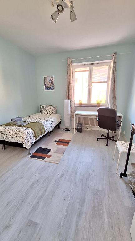 Schlafzimmer mit einem Bett, einem Schreibtisch und einem Fenster in der Unterkunft Room near Triangeln Station- shared kitchen and bathroom in Malmö