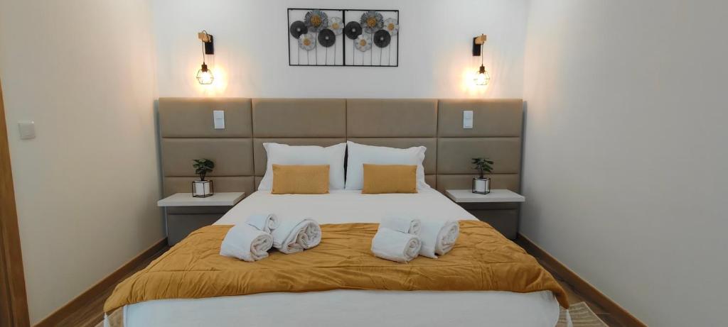 Un dormitorio con una cama con zapatos blancos. en Suíte Inês, en Alijó