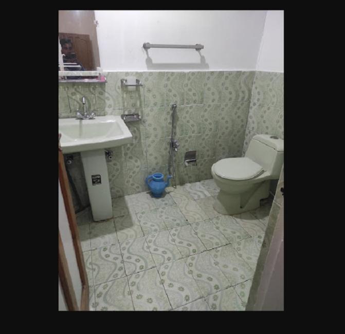 un baño con inodoro y lavabo en Zago Guest House, en Skardu