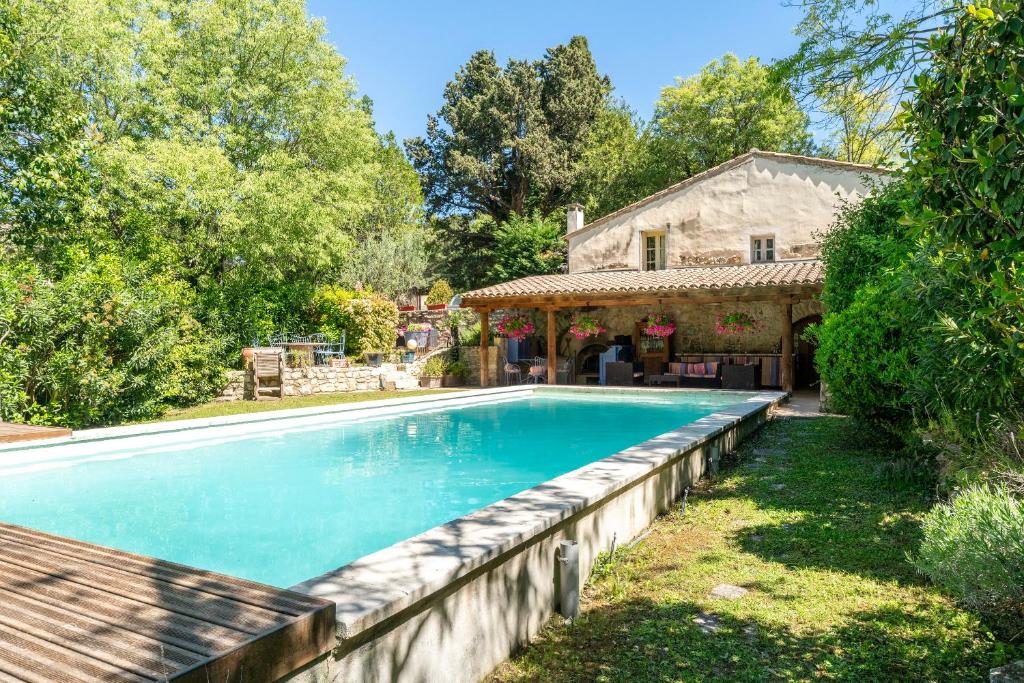 a swimming pool in a yard next to a house at Le Moulin in Saint-Rémy-de-Provence